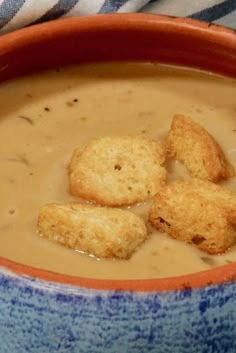 a bowl filled with soup and croutons sitting on top of a blue and white towel