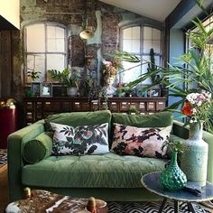 a living room filled with furniture and lots of plants