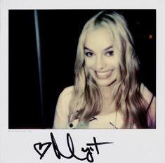 a woman with long blonde hair smiling at the camera