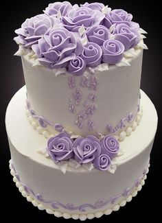 a three tiered cake with purple flowers on top