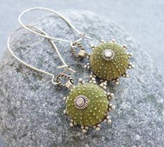 Living in Turkey has some big advantages, like the beautiful abandoned beaches with just you, the sea and the blue sky. During our long beach walks, we often find all kind of treasures as sea urchins and shells. These earrings are one of the treasures born of our findings. We clean the sea urchins, fill and cover them to make them strong. The sea urchins are adorned with bead caps and a beautiful filigree piece at the back. The earrings are 2 3/8'' (6 cm), including the long leaver back wires. All metal is nickel and lead free. Will be sent by registered airmail. More sea urchin jewelry is coming up, and we will gladly make the custom order to your wishes and dreams with sea urchins! Two shipping options: Registered airmail takes 15 - 30 days on average,it is cheap and safe but slow. TNT w Drunken Sailor, How To Sail, River Stream, Ocean Vacation, Beach Glass Jewelry, Vacation Tropical, Tropical Fashion, Sea Urchins, Beach Walks