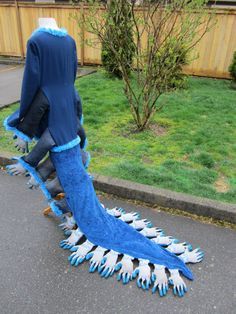 a man dressed in blue and white is walking down the street with his foot on an animal rug