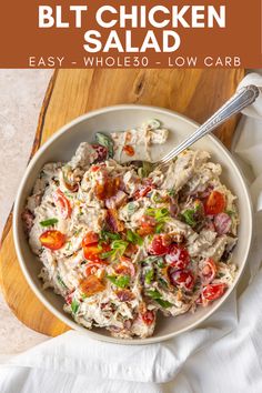 a white bowl filled with salad on top of a wooden cutting board next to a spoon