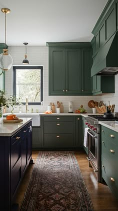 a kitchen with green cabinets and an area rug