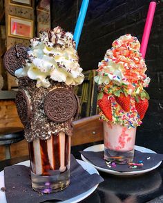 two ice cream sundaes are sitting on plates