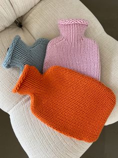 three knitted vases sitting on top of a white couch