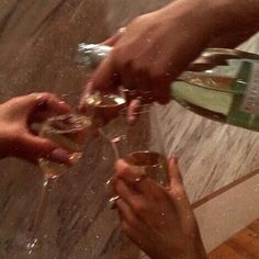 several people are toasting with wine glasses in front of each other on the floor