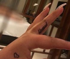 a woman's hand with the word mama tattooed on her left thumb and fingers