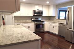 a kitchen with stainless steel appliances and white cabinets