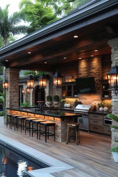 an outdoor kitchen with bar seating and lights