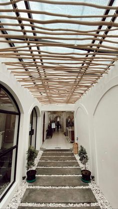 an indoor area with stairs and potted plants on either side of the entrance door