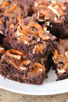 a white plate topped with brownies covered in nuts