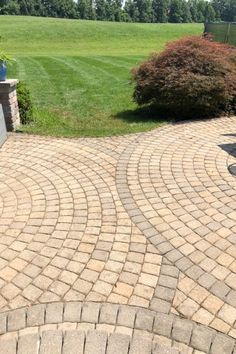 a brick patio in the middle of a yard