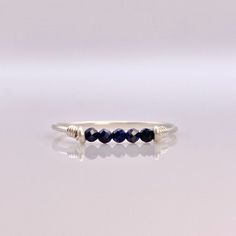 This beautifully simple ring is lovingly handmade with 5 tiny Sapphire gemstones and a choice of 14k Gold Filled, 14k Rose Gold Filled or Sterling Silver band. M A T E R I A L S: * Sapphire * 14k Gold Filled, 14k Rose Gold Filled or Sterling Silver S I Z E: *  Gemstone - Approximately 2mm each *  Band Thickness - Approximately 0.8-1mm  All of our jewellery is carefully handmade using good quality materials and handpicked gemstones, with the aim to produce quality pieces that you can love & wear Dainty Adjustable Sapphire Ring For Anniversary, Minimalist Sterling Silver Birthstone Ring, Simple Adjustable Round Band Jewelry, Sterling Silver Birthstone Ring For Everyday, Adjustable Sterling Silver Sapphire Ring, Everyday Sterling Silver Birthstone Ring With Gemstone, Elegant Everyday Wire Wrapped Rings, Fine Jewelry Sterling Silver Midi Rings With Birthstone, Sterling Silver Birthstone Midi Rings