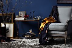 a living room with blue walls and white fur on the floor, an old fashioned chair sits in front of it