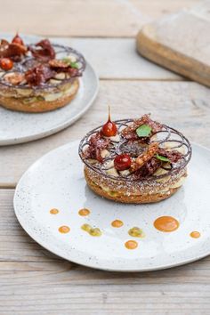 two white plates topped with cakes covered in toppings