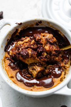 a white bowl filled with chocolate sauce on top of a table