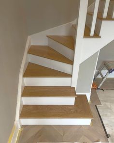 the stairs are painted white and have wood treads on them, along with carpeted flooring