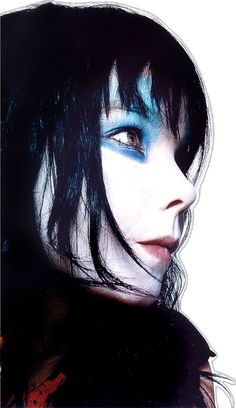 a woman with black hair and blue makeup