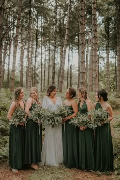 a group of women standing next to each other in the woods