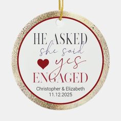 a christmas ornament with the words he asked she said yes engaged