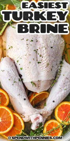 a whole turkey in a bowl with oranges and herbs