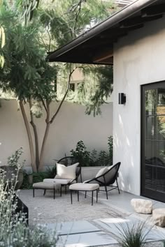 an outdoor living area with chairs and plants