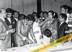 an old black and white photo of people cutting a cake