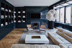 a living room filled with furniture and bookshelves next to a fire place in front of a window