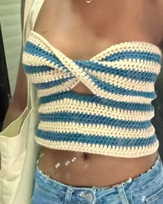 a close up of a person wearing a top with crocheted stripes on it