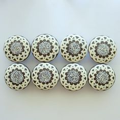 six white and brown decorative knobs on a table