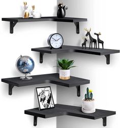 three black shelves on the wall with various items and decorations in front of each shelf