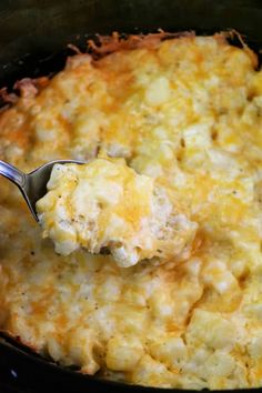 a spoonful of macaroni and cheese is being lifted from the crockpot