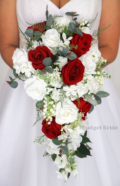 a bride holding a bouquet of red and white flowers