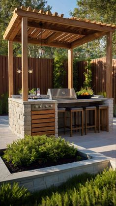 an outdoor kitchen and grill area in a backyard