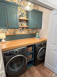 a washer and dryer in a small room with green cabinets on the wall