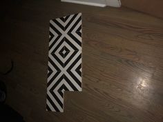 a piece of black and white paper sitting on top of a wooden floor