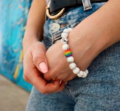 Introducing the Simple Volcanic Stone Bracelet from RoseGoldCo - a trendy and stylish accessory that is perfect for adding some personality and flair to your outfit. This bracelet features a rainbow design that shows your support for the LGBTQ+ community and adds a pop of color to your look. Crafted from high-quality volcanic stone, this bracelet is not only durable but also has energy stone properties that can provide a sense of calm and grounding. The rainbow design adds a touch of personality Trendy Rainbow Jewelry For Pride, Trendy Jewelry For Pride Gifts, Gay Pride Bracelet, Stone Properties, Bracelet Rainbow, Pride Bracelet, Fashionable Accessories, Volcanic Stone, Stone Bracelets