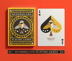 two playing cards on an orange background with the words meadowlark and playing cards