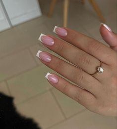 a woman's hand with pink and white manicured nails