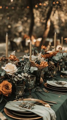 the table is set with candles, plates and napkins for an elegant dinner party