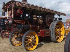 an old fashioned steam engine on display at a car and truck show in the country