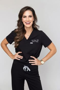 a woman in black scrubs posing for the camera with her hands on her hips