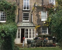 an old brick building with lots of windows and ivy growing on it's sides