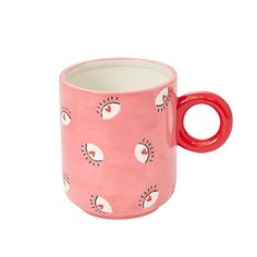 a pink coffee mug with eyes on it