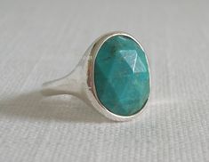 "Faceted oval stabilized Turquoise stone set in smooth hand tooled Sterling Silver Band. Stone measures 7/16\" (1.1cm) wide, 9/16\" (1.4cm) high; band is 1/8\" (2mm) wide. The Ring was used for display only by a Silpada Rep, and was retired from the 2015 catalog. It is in PERFECT ~ LIKE NEW ~ CONDITION, and sold for $69.00 + tax and shipping. If you would like a Silpada bag or box, please request with payment. All items are stored in a temperature controlled, smoke free environment. Silpada jewelry is of exceptional quality, made with detailed craftsmanship, and designed by artisans from around the world. All pieces are best quality sold .925 sterling silver and stamped; plus the finest semi-precious, composite, and man-made materials available. Most designs are proprietary or exclusive to Adjustable Oval Turquoise Ring With Large Stone, Silpada Jewelry, Sterling Silver Bands, Turquoise Gemstone, Turquoise Sterling Silver, 925 Sterling Silver Jewelry, Turquoise Stone, Silver Band, 925 Sterling Silver Ring