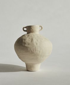 a white vase sitting on top of a table