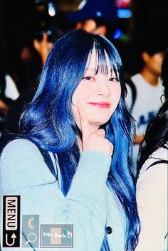 a woman with blue hair and bangs posing for a photo in front of a crowd