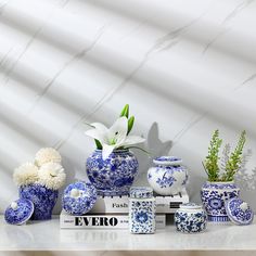 blue and white vases with flowers in them on a table