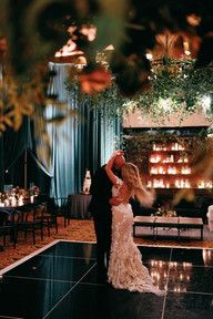 a bride and groom dance together in front of candles on the dance floor at their wedding reception